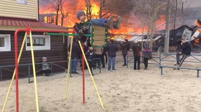 Мальчик на качелях на фоне пожара поразил Сеть (видео)